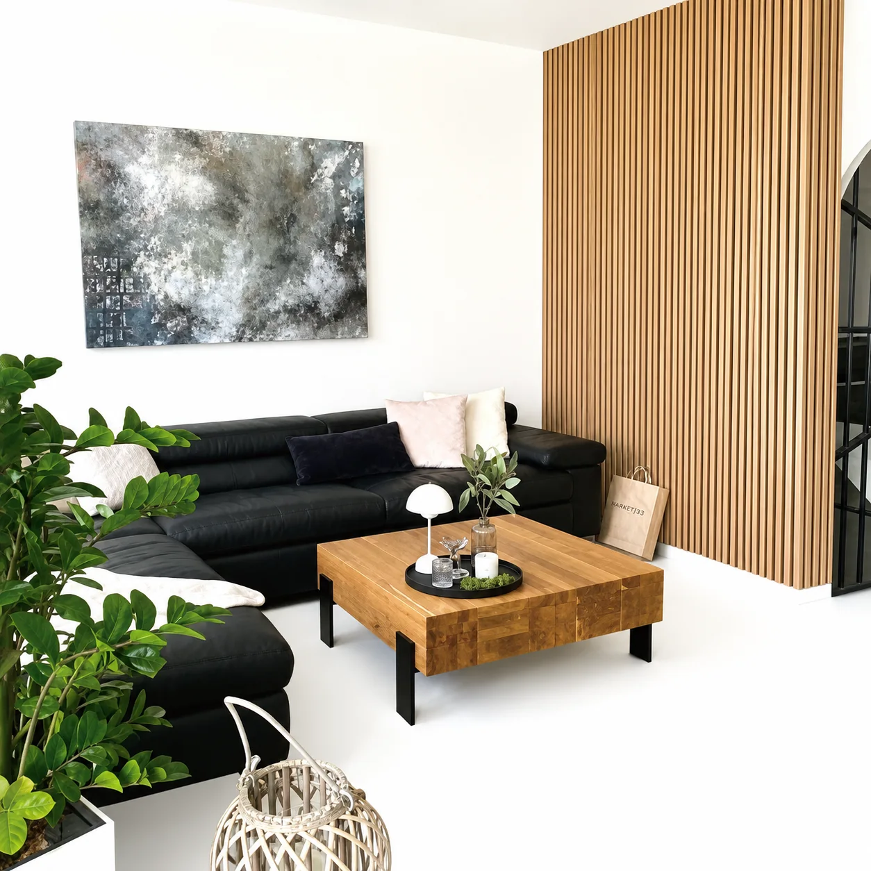 Bright living room with black sofa and light oak slat wall